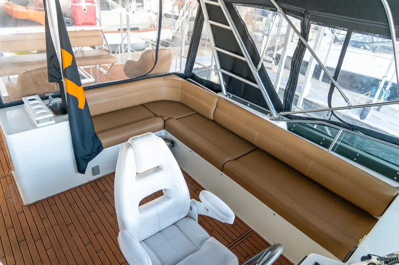 Slide: The Image of 1997 Harbor Master Stolkraft boat interior with tan seating and white captain's chair. - 33