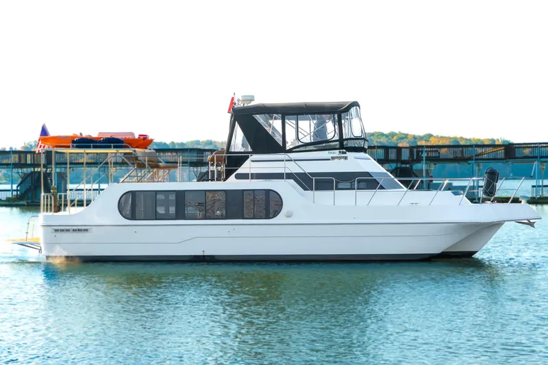 Slide: The Image of 1997 Harbor Master Stolkraft boat docked on calm water, featuring sleek design and spacious cabin. - 5