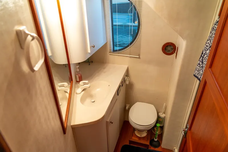 Slide: The Image of Compact bathroom in a 1997 Harbor Master Stolkraft boat with sink, toilet, and porthole window. - 54