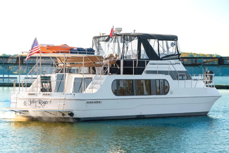 Slide: The Image of 1997 Harbor Master Stolkraft yacht on water, featuring "Jolly Roger II" name and American flag. - 6