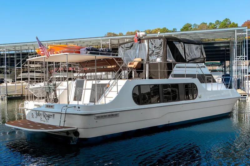 Slide: The Image of 1997 Harbor Master Stolkraft yacht docked, featuring upper deck and American flag. - 9
