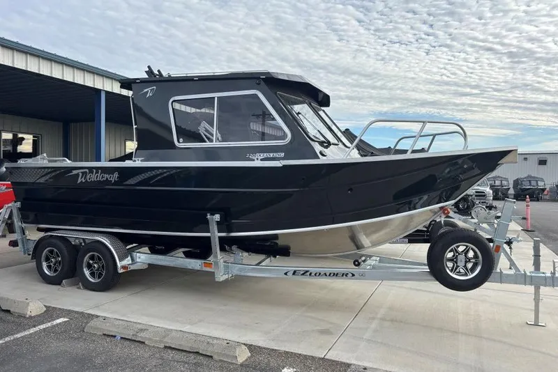 The Image of 2026 Weldcraft 220 Ocean King boat on trailer, parked outdoors under cloudy sky. - 1