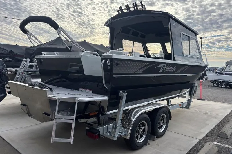Slide: The Image of 2026 Weldcraft 220 Ocean King boat on trailer under cloudy sky. - 2