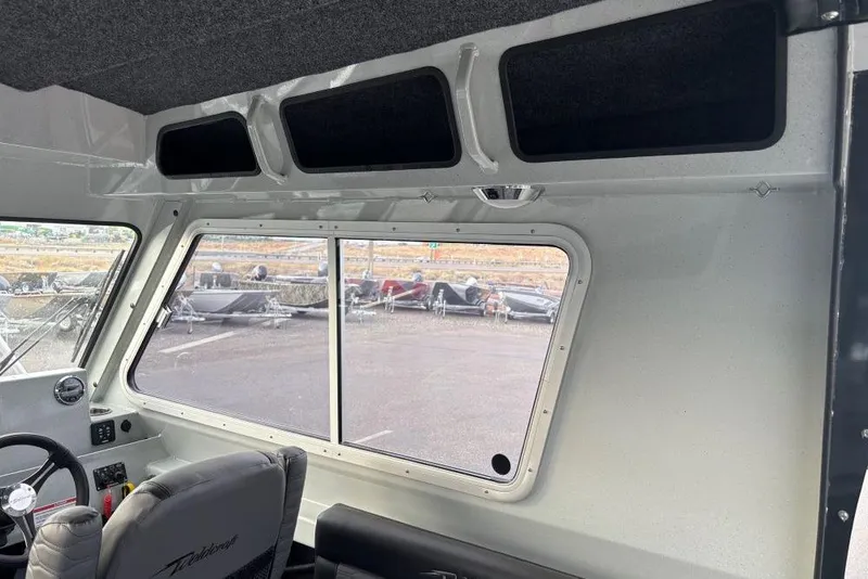Slide: The Image of Interior view of 2026 Weldcraft 220 Ocean King boat, featuring window and seating. - 9