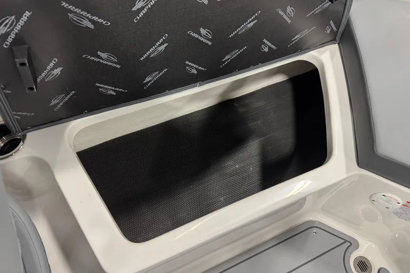 Slide: The Image of Storage compartment in 2026 Chaparral 23 SSi boat, featuring branded interior lining. - 51