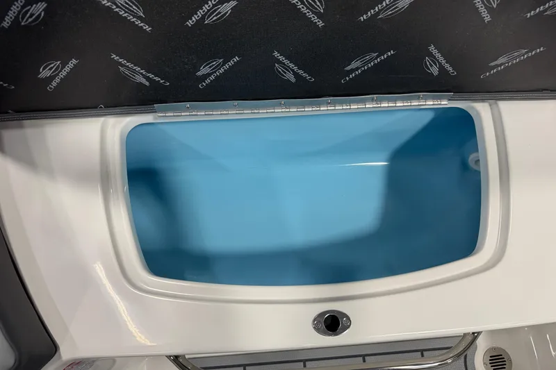 Slide: The Image of 2026 Chaparral 23 SSi boat storage compartment with blue interior and Chaparral branding. - 52