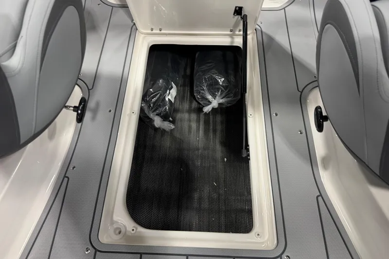 Slide: The Image of 2026 Chaparral 23 SSi boat storage compartment with gray interior and seating. - 54