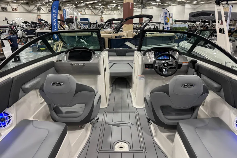 Slide: The Image of 2026 Chaparral 23 SSi boat interior with modern seating and dashboard at a boat show. - 64
