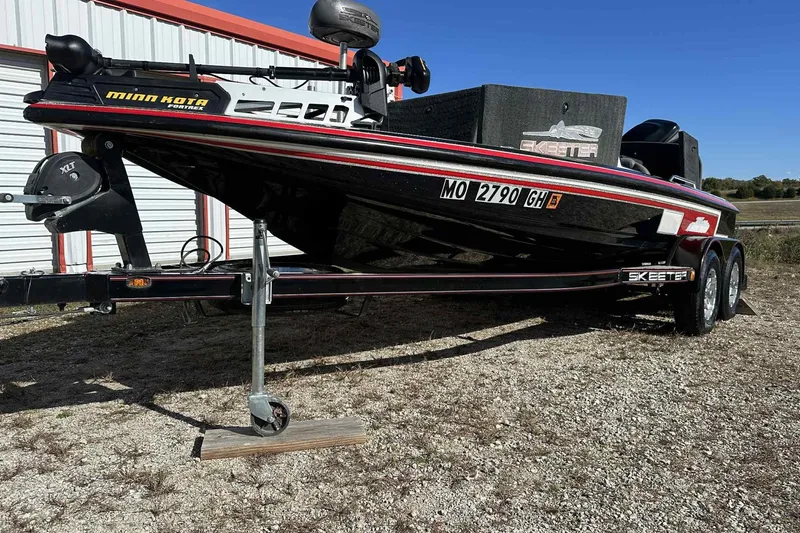 The Image of 2003 Skeeter ZX200 boat on trailer, parked outdoors near a storage building. - 1