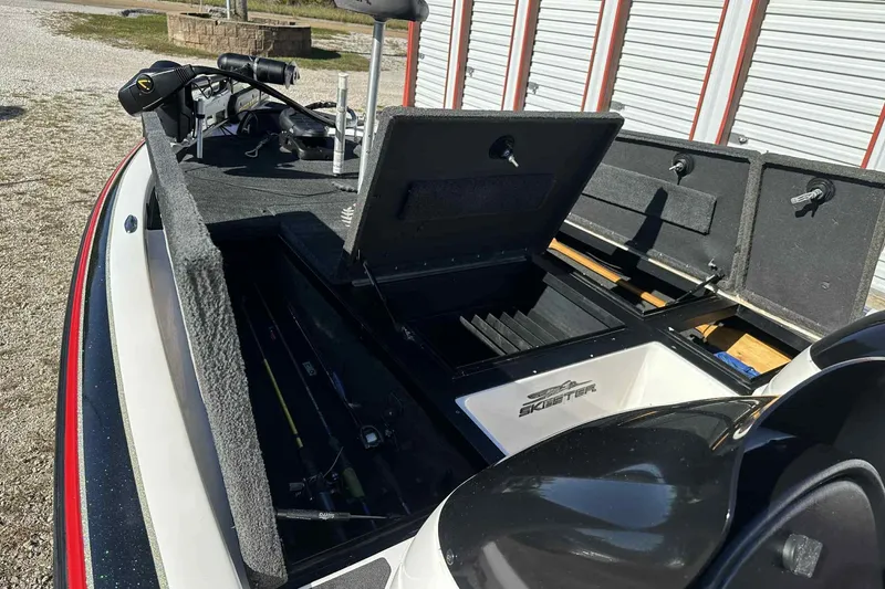 Slide: The Image of 2003 Skeeter ZX200 boat with open storage compartments and fishing gear. - 12