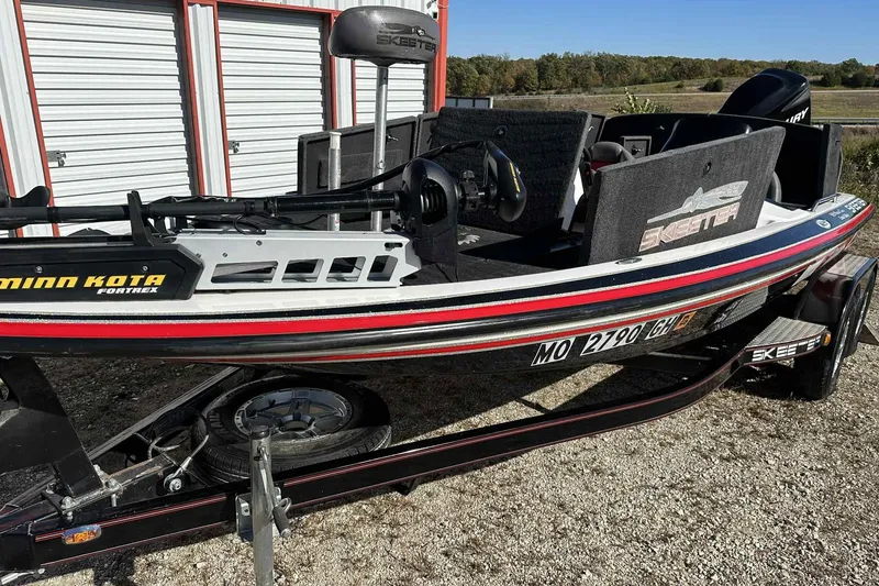 Slide: The Image of 2003 Skeeter ZX200 boat with Minn Kota Fortrex motor, parked near storage units. - 16
