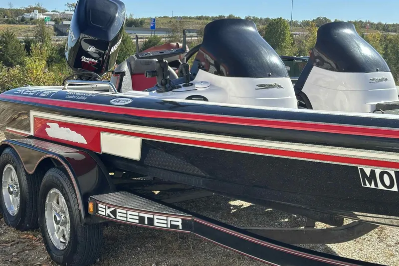 Slide: The Image of 2003 Skeeter ZX200 boat with dual engines on a trailer, parked outdoors. - 18