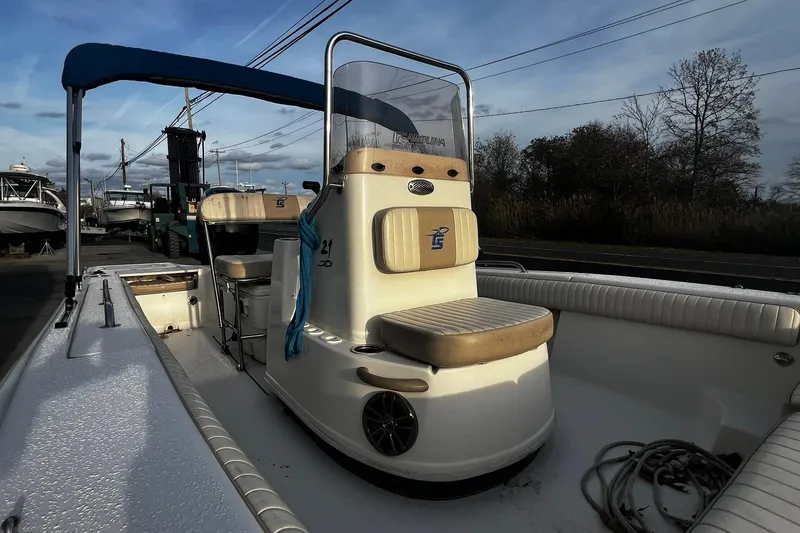 Slide: The Image of 2016 Carolina Skiff EV218 Sea Skiff with blue canopy, docked outdoors. - 11