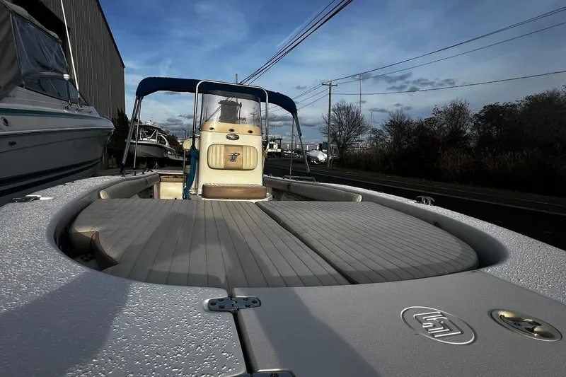 Slide: The Image of 2016 Carolina Skiff EV218 Sea Skiff boat with blue canopy, docked outdoors. - 12