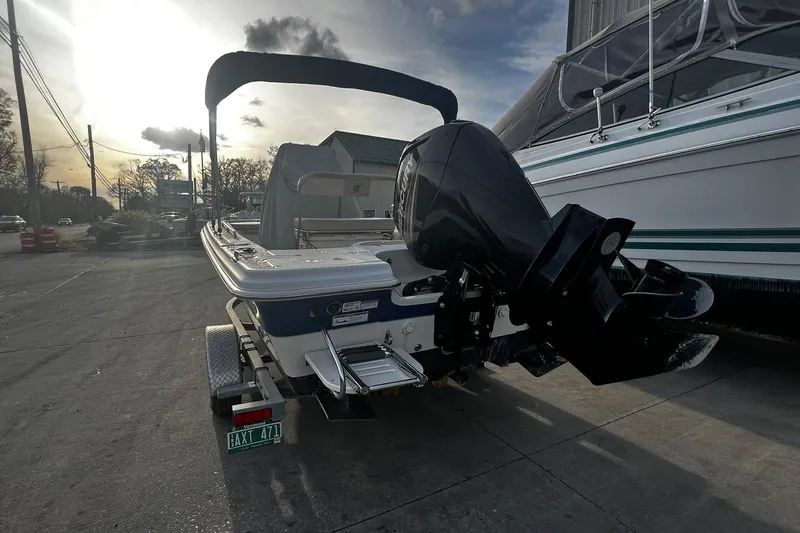 Slide: The Image of 2016 Carolina Skiff EV218 Sea Skiff with outboard motor on trailer, parked outdoors. - 2