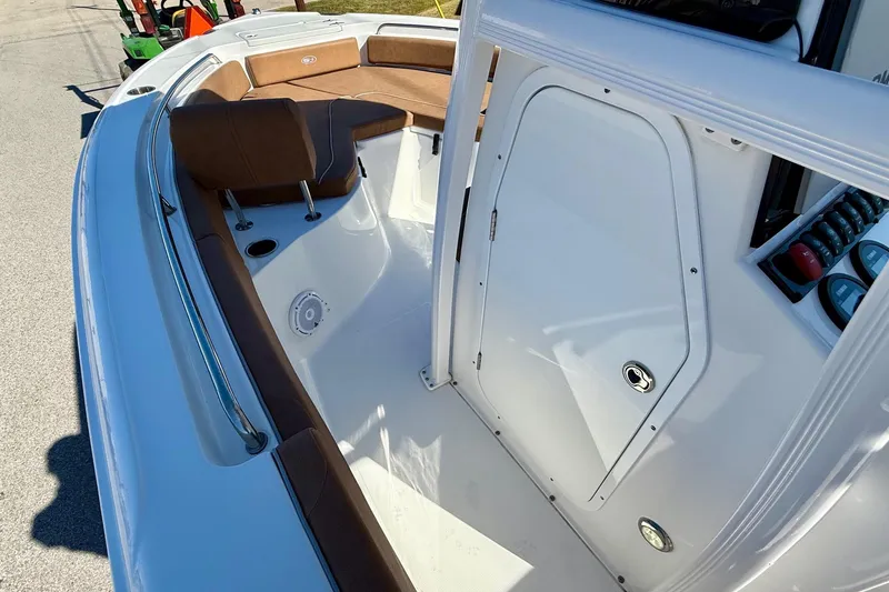 Slide: The Image of 2023 Sea Hunt Ultra 234 boat interior with brown seating and white console. - 12