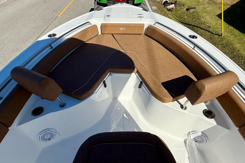 Slide: The Image of 2023 Sea Hunt Ultra 234 boat interior with brown cushioned seating and cup holders. - 14