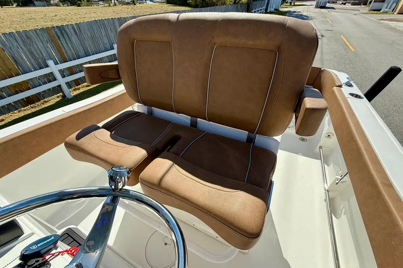 Slide: The Image of 2023 Sea Hunt Ultra 234 boat with brown cushioned seating and steering wheel. - 9