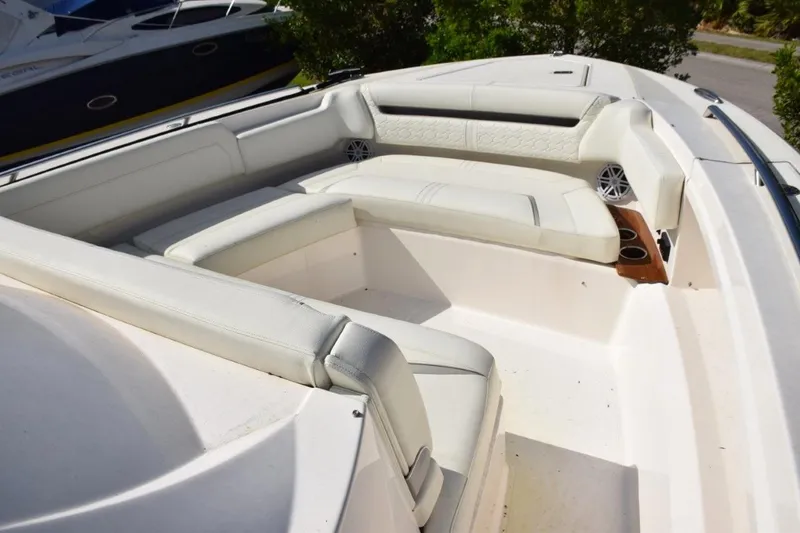 Slide: The Image of 2024 Tiara Yachts 38 LS, triple helm chairs, fold-up standing bolsters, fold down armrests. Electric adjustable center, drink refrigerator beneath starboard side, footrests - 6