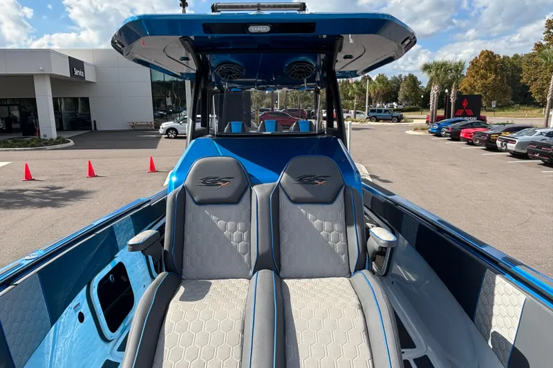 Slide: The Image of 2024 GSX 36 boat interior with dual seats, blue and gray design, outdoor dealership setting. - 20