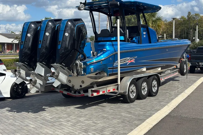 Slide: The Image of 2024 GSX 36 boat with triple outboard engines on a trailer, parked outdoors. - 3
