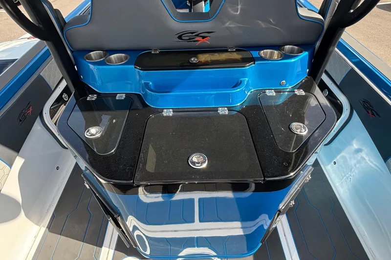 Slide: The Image of 2024 GSX 36 boat interior with blue and black console, cup holders, and storage compartments. - 36