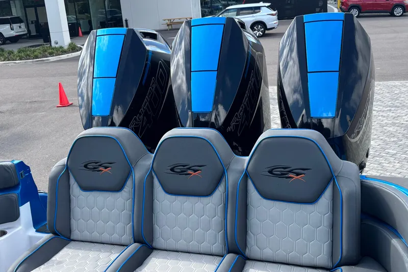 Slide: The Image of 2024 GSX 36 boat with triple outboard engines and stylish seating, parked outdoors. - 9