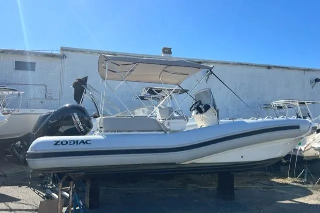 Slide: The Image of 2023 Zodiac N-ZO 680 boat with canopy, docked outdoors under clear blue sky. - 0