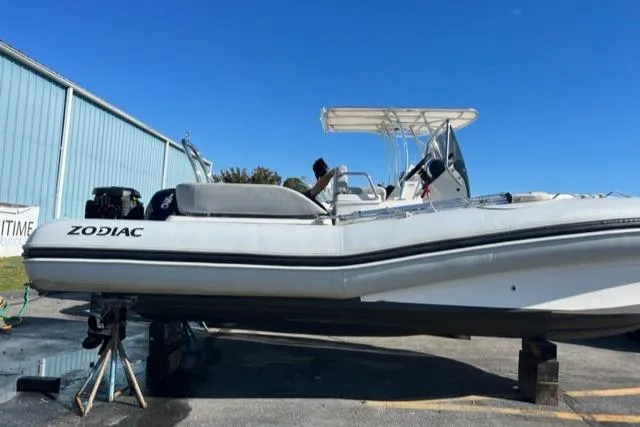Slide: The Image of 2023 Zodiac N-ZO 680 boat on stands, side view, clear blue sky. - 2