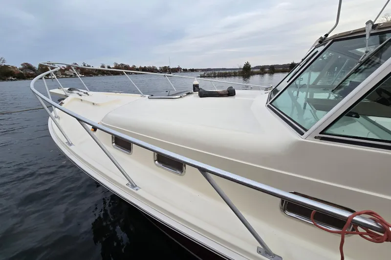 Slide: The Image of Side view of 2001 Mainship 30 Pilot Rum Runner boat with portholes and railing. - 11