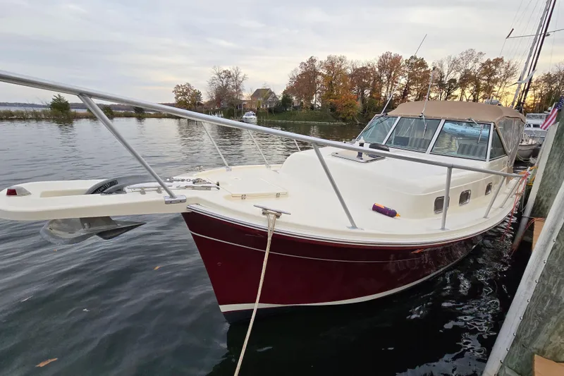 Slide: The Image of 2001 Mainship 30 Pilot Rum Runner boat interior with striped seating and decorative pillows. - 13