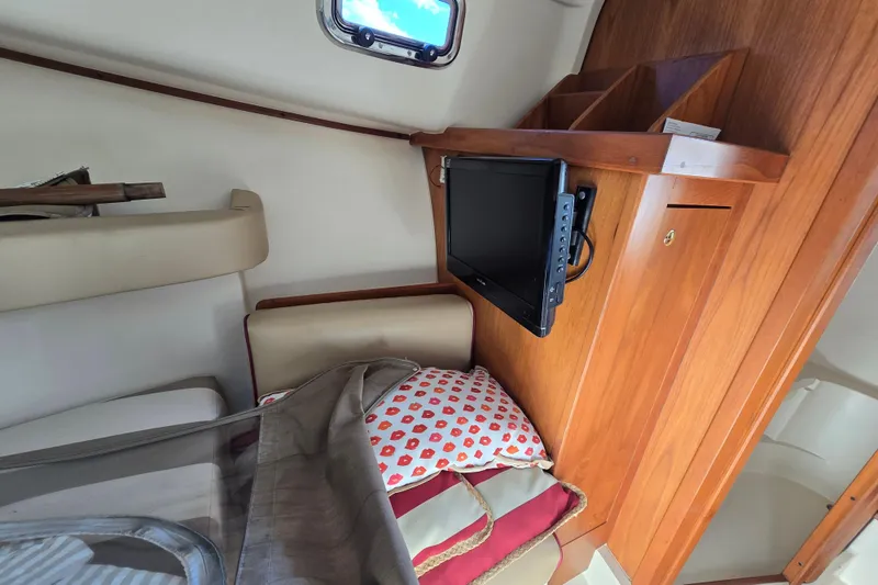 Slide: The Image of 2001 Mainship 30 Pilot Rum Runner cabin with kitchenette, seating, and wooden accents. - 35