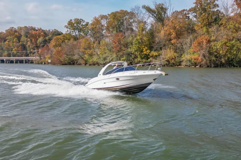 Slide: The Image of 2007 Sea Ray 290 Sun Sport cruising on a scenic lake with autumn foliage. - 10