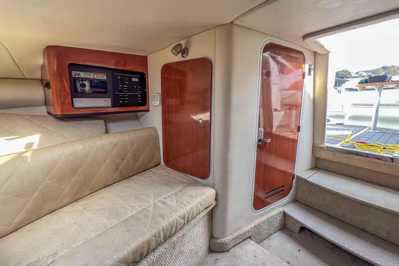 Slide: The Image of Interior of 2007 Sea Ray 290 Sun Sport boat with beige seating and wooden accents. - 14