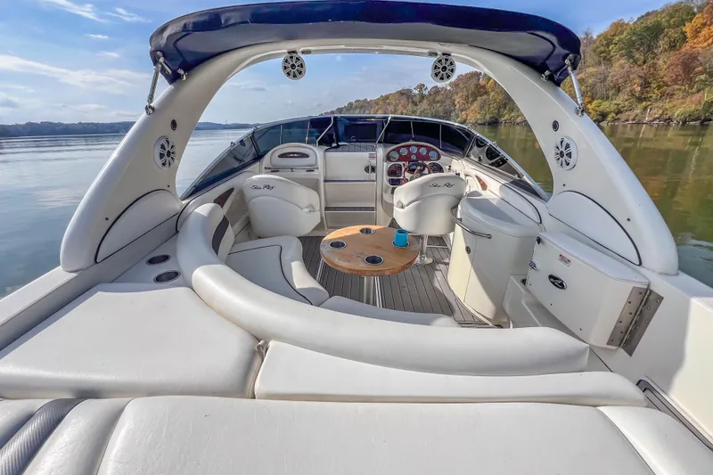 Slide: The Image of 2007 Sea Ray 290 Sun Sport boat interior with seating and helm, on a calm lake. - 16
