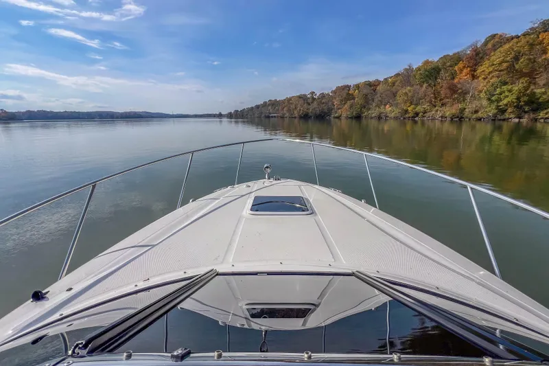 Slide: The Image of 2007 Sea Ray 290 Sun Sport cruising on a serene lake with autumn foliage. - 20