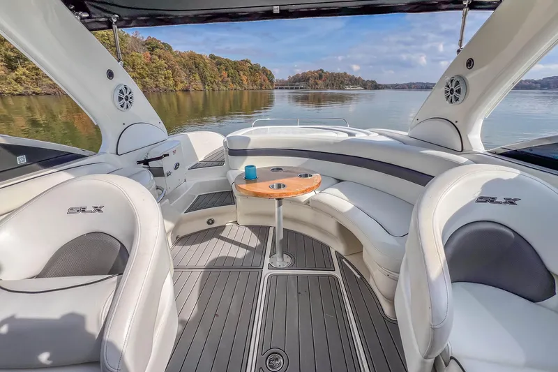Slide: The Image of 2007 Sea Ray 290 Sun Sport boat interior with seating and table on a calm lake. - 22