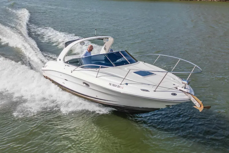 Slide: The Image of 2007 Sea Ray 290 Sun Sport cruising on a lake with a person at the helm. - 8