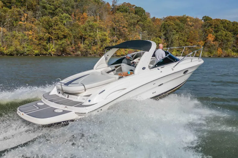 Slide: The Image of 2007 Sea Ray 290 Sun Sport cruising on a lake with autumn foliage backdrop. - 9