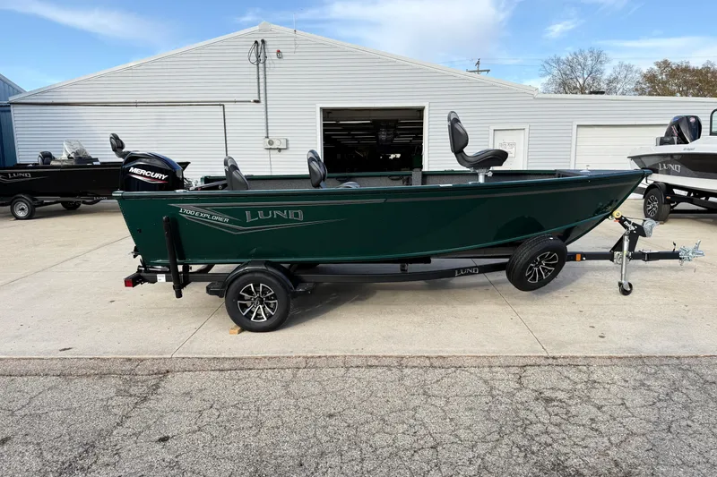 The Image of 2026 Lund 1700 Explorer Tiller boat on trailer, parked outside a garage. - 0