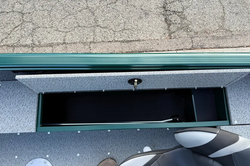 Slide: The Image of 2026 Lund 1700 Explorer Tiller boat storage compartment with open lid, showing interior space. - 14