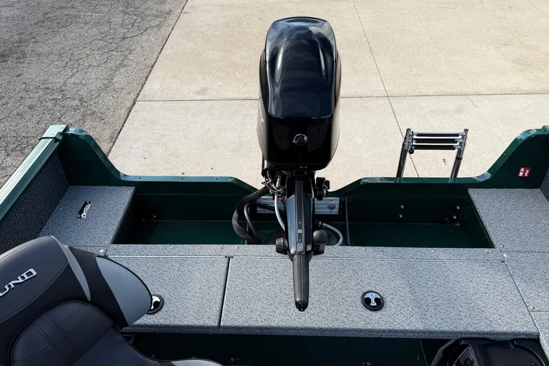 Slide: The Image of 2026 Lund 1700 Explorer Tiller boat with motor and seating, docked on concrete. - 18