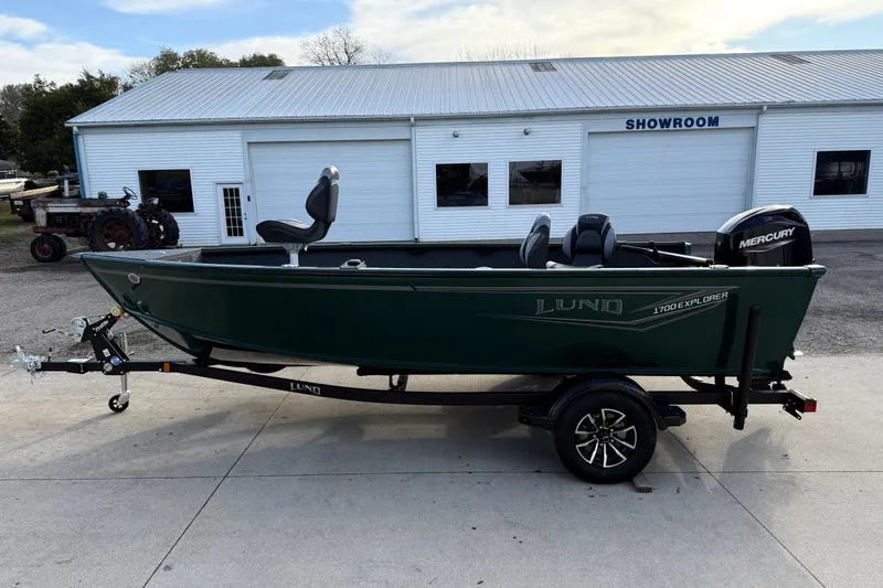 Slide: The Image of 2026 Lund 1700 Explorer Tiller boat on trailer outside showroom. - 4
