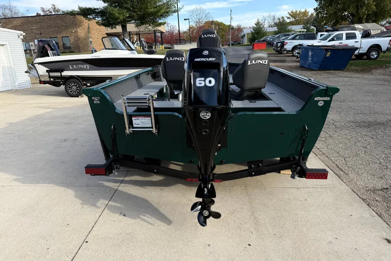 Slide: The Image of 2026 Lund 1700 Explorer Tiller boat with Mercury 60 engine, parked outdoors. - 6