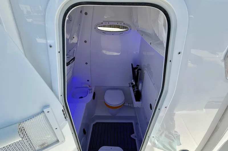 Slide: The Image of Interior of 2026 Sea Hunt Gamefish 30 Coffin Box boat, featuring a compact marine toilet. - 14