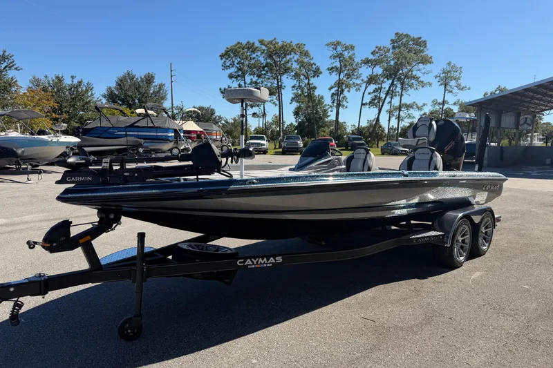 Slide: The Image of 2026 Caymas XS 21 Pro boat on trailer, parked outdoors under clear blue sky. - 4