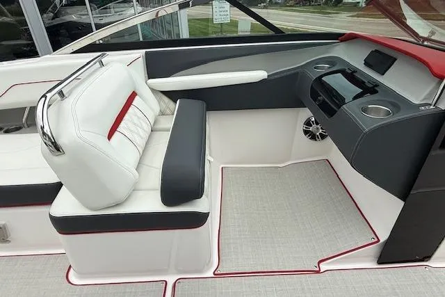 Slide: The Image of 2021 Regal LS4 Surf boat interior with white and gray seating, modern dashboard, and cup holders. - 13