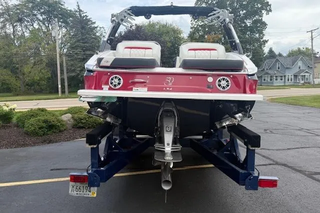 Slide: The Image of 2021 Regal LS4 Surf boat on trailer, rear view, parked outdoors. - 2