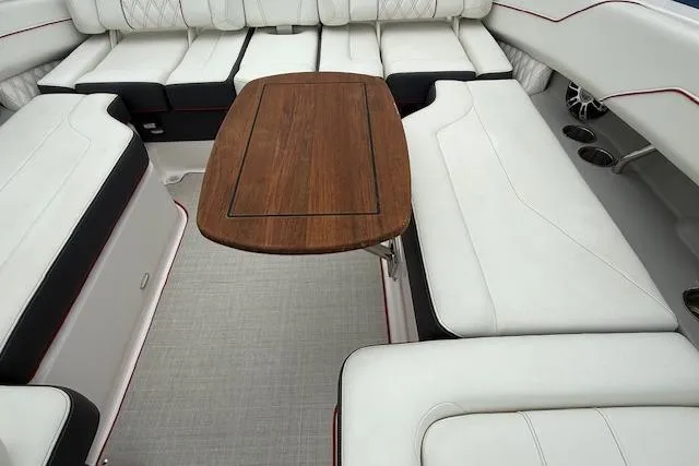 Slide: The Image of 2021 Regal LS4 Surf boat interior with white seating and wooden table. - 21