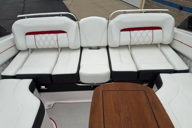 Slide: The Image of 2021 Regal LS4 Surf boat interior with white cushioned seating and wooden table. - 22
